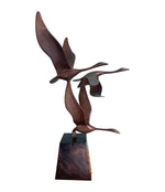 A French 1960s Mid century bronze sculpture by Lumiere of three flying swans mounted on a bronze base,