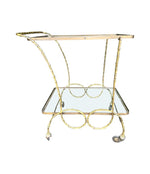 A pretty French 1950s solid brass faux bamboo bar trolley by Maison Baques with two glass shelves