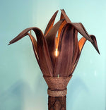 An unusual palm tree floor lamp with real palm trunk, wooden base and wooden shaped leaves