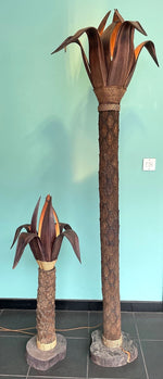 An unusual palm tree floor lamp with real palm trunk wooden base and wooden shaped leaves