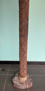 An unusual palm tree floor lamp with real palm trunk, wooden base and wooden shaped leaves