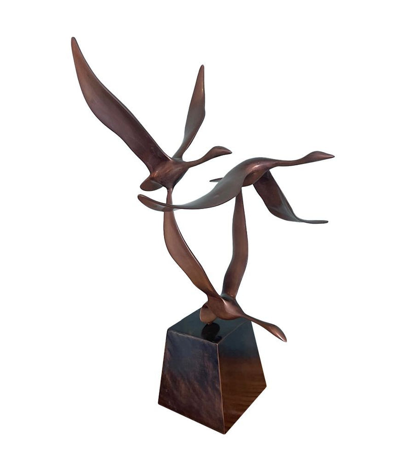 A French 1960s Mid century bronze sculpture by Lumiere of three flying swans mounted on a bronze base,