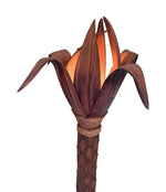 An unusual palm tree floor lamp with real palm trunk, wooden base and wooden shaped leaves