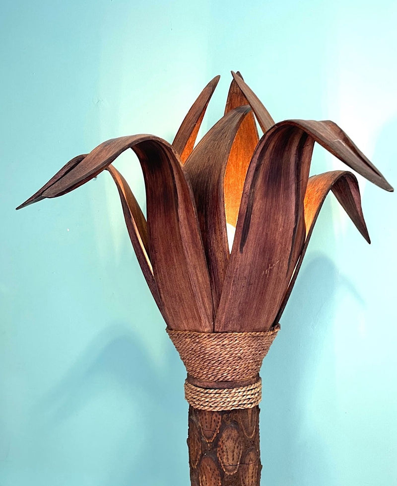 An unusual palm tree floor lamp with real palm trunk wooden base and wooden shaped leaves