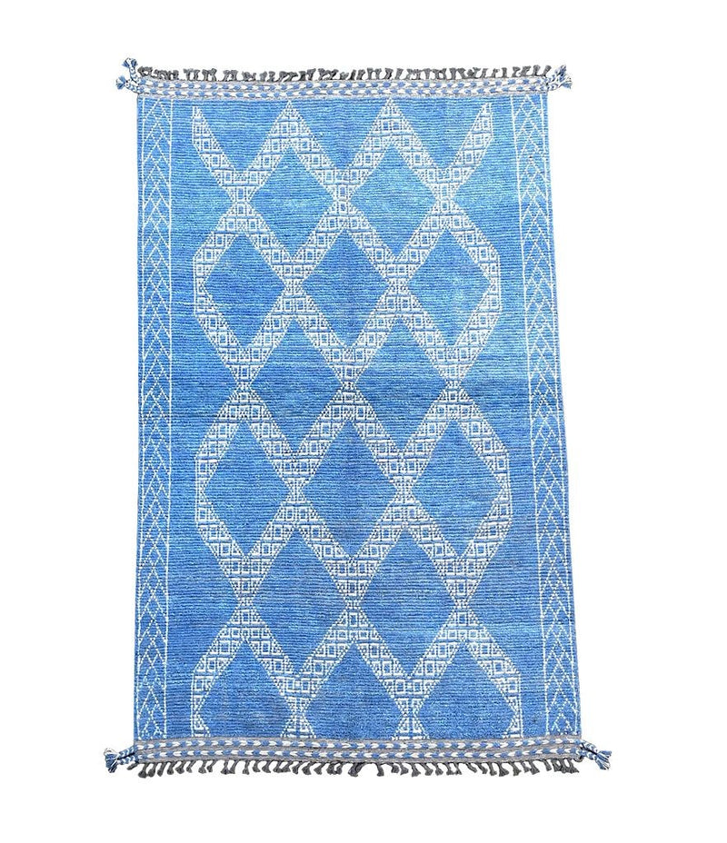 A good quality handmade Morrocan Beni Ourain with white tribal diamond and line pattern on blue background