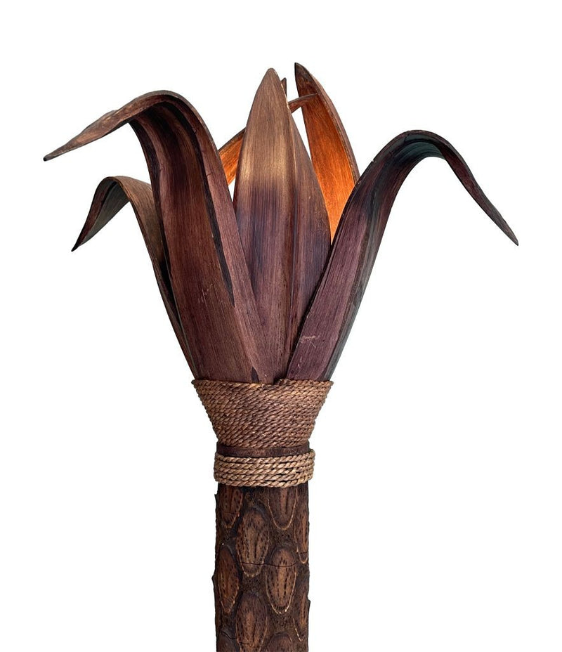 An unusual palm tree floor lamp with real palm trunk, wooden base and wooden shaped leaves