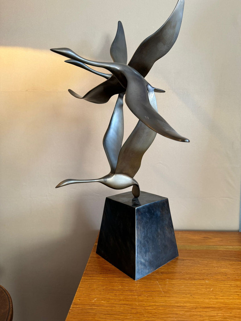 A French 1960s Mid century bronze sculpture by Lumiere of three flying swans mounted on a bronze base,