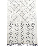 A large handwoven Moroccan Beni Ourain wool berber rug with tribal diamond and line pattern