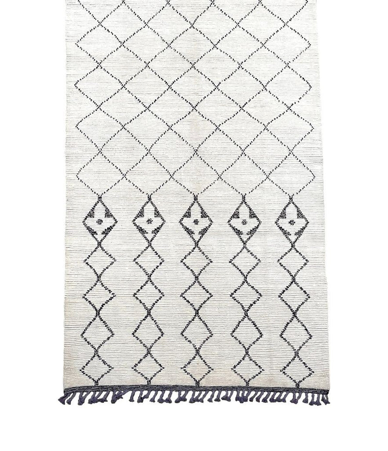 A large handwoven Moroccan Beni Ourain wool berber rug with tribal diamond and line pattern