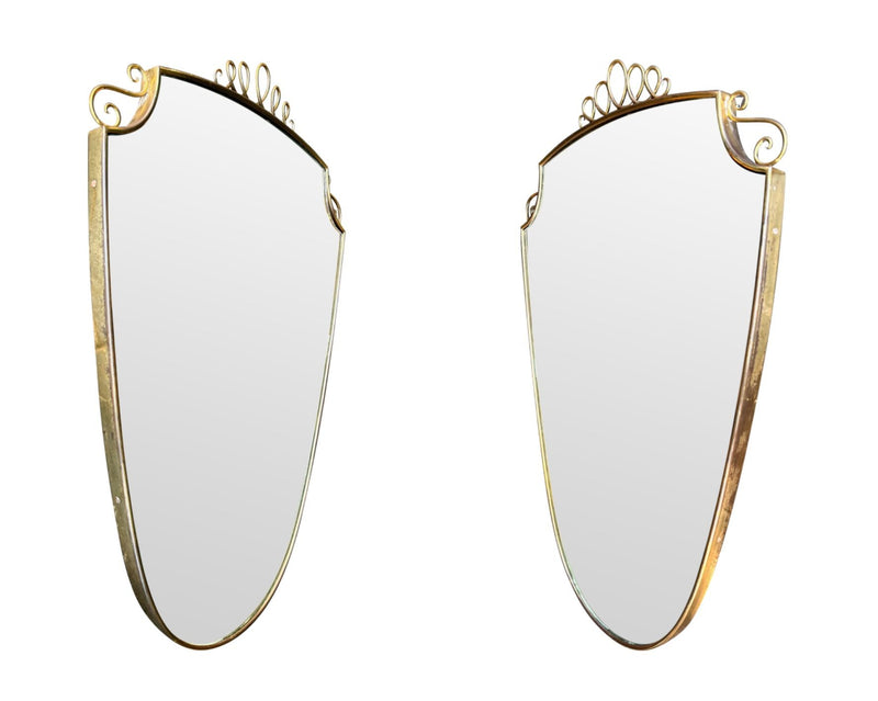 An orignal pair of 1950s Gio Ponti style Italian portrait brass framed mirror with brass top scroll detailing
