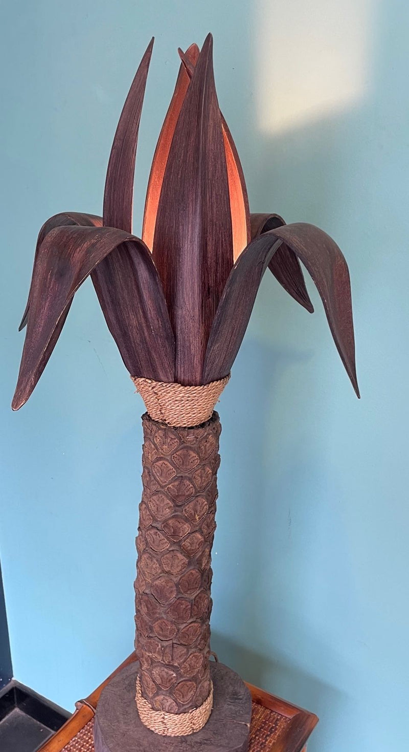 An unusual palm tree floor lamp with real palm trunk wooden base and wooden shaped leaves