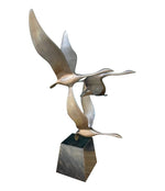 A French 1960s Mid century bronze sculpture by Lumiere of three flying swans mounted on a bronze base,