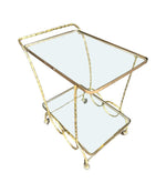 A pretty French 1950s solid brass faux bamboo bar trolley by Maison Baques with two glass shelves