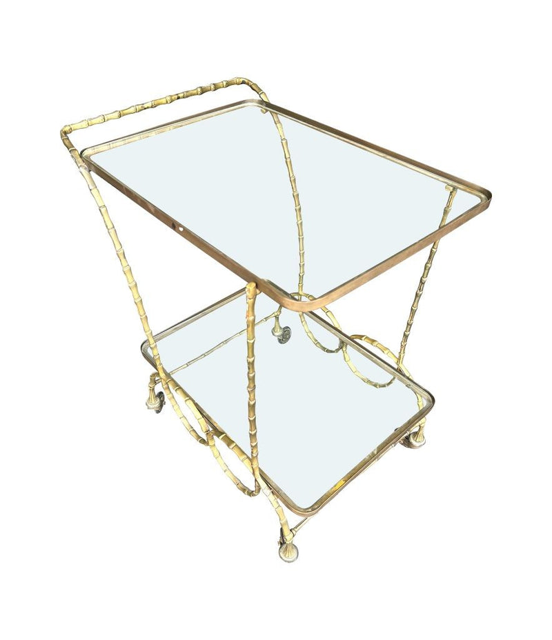 A pretty French 1950s solid brass faux bamboo bar trolley by Maison Baques with two glass shelves