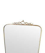 Mid century brass framed mirror with slim profile and scroll top detail