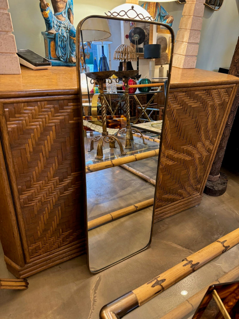 Mid century brass framed mirror with slim profile and scroll top detail