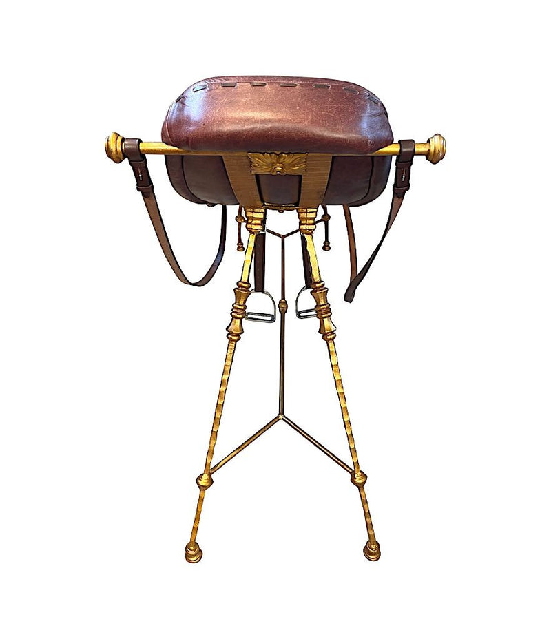 A Mark Brazier Jones "Tally Ho" chair a sculptural chair upholstered in a tan leather, with leather reigns, straps and steel stirrups on a stylised gilt wrought iron frame