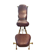 A Mark Brazier Jones "Tally Ho" chair a sculptural chair upholstered in a tan leather, with leather reigns, straps and steel stirrups on a stylised gilt wrought iron frame