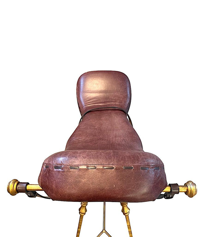 A Mark Brazier Jones "Tally Ho" chair a sculptural chair upholstered in a tan leather, with leather reigns, straps and steel stirrups on a stylised gilt wrought iron frame